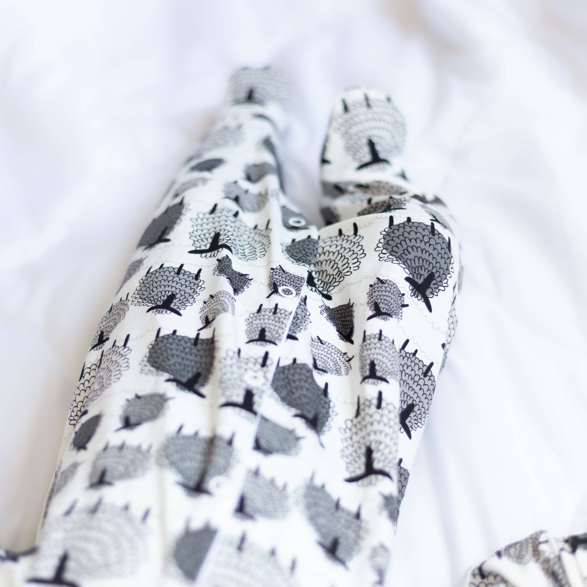 Patterned fabric with black and gray sheep design on a white background