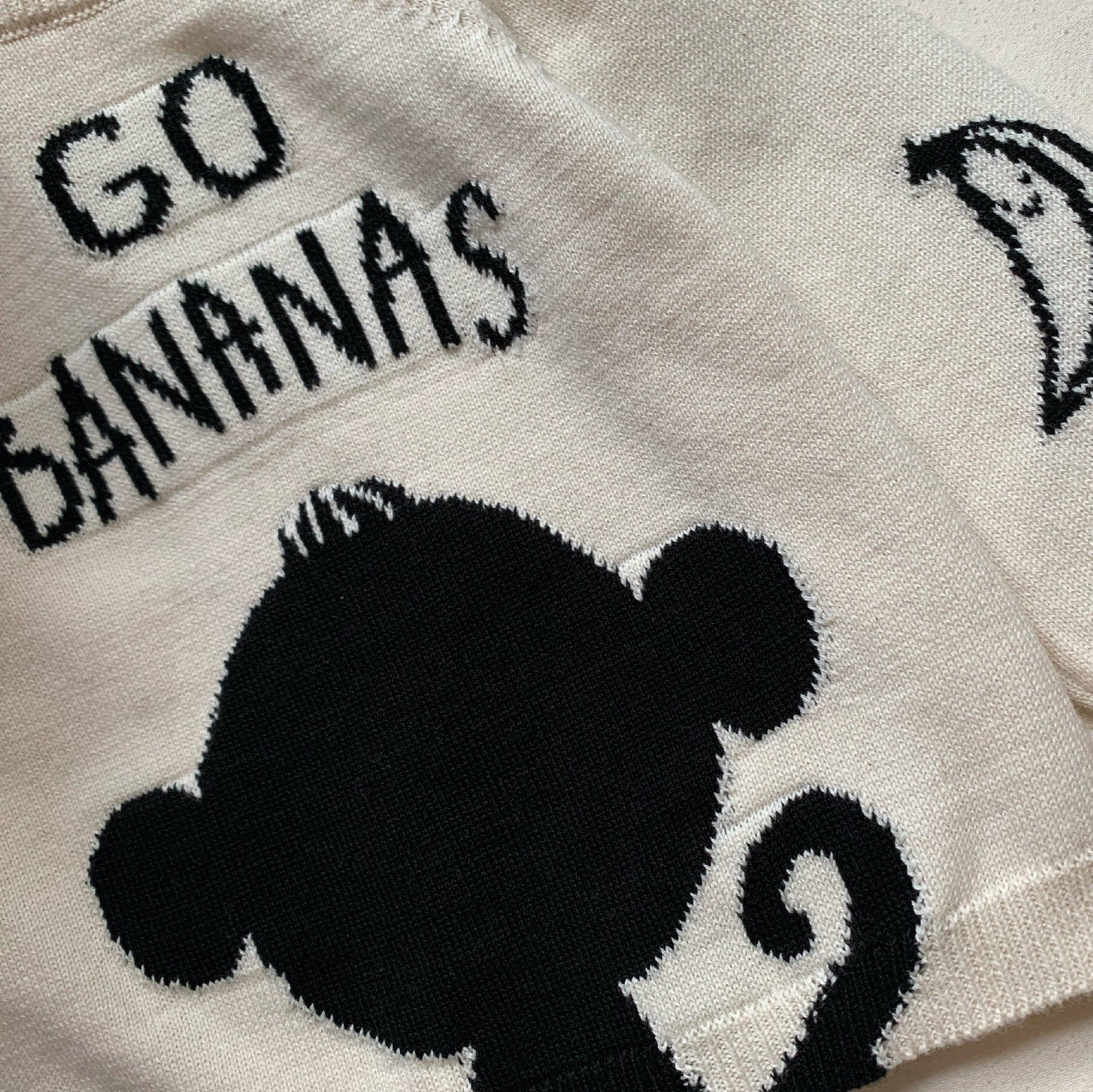 White jumper/sweater with black text and banana graphic on a white background