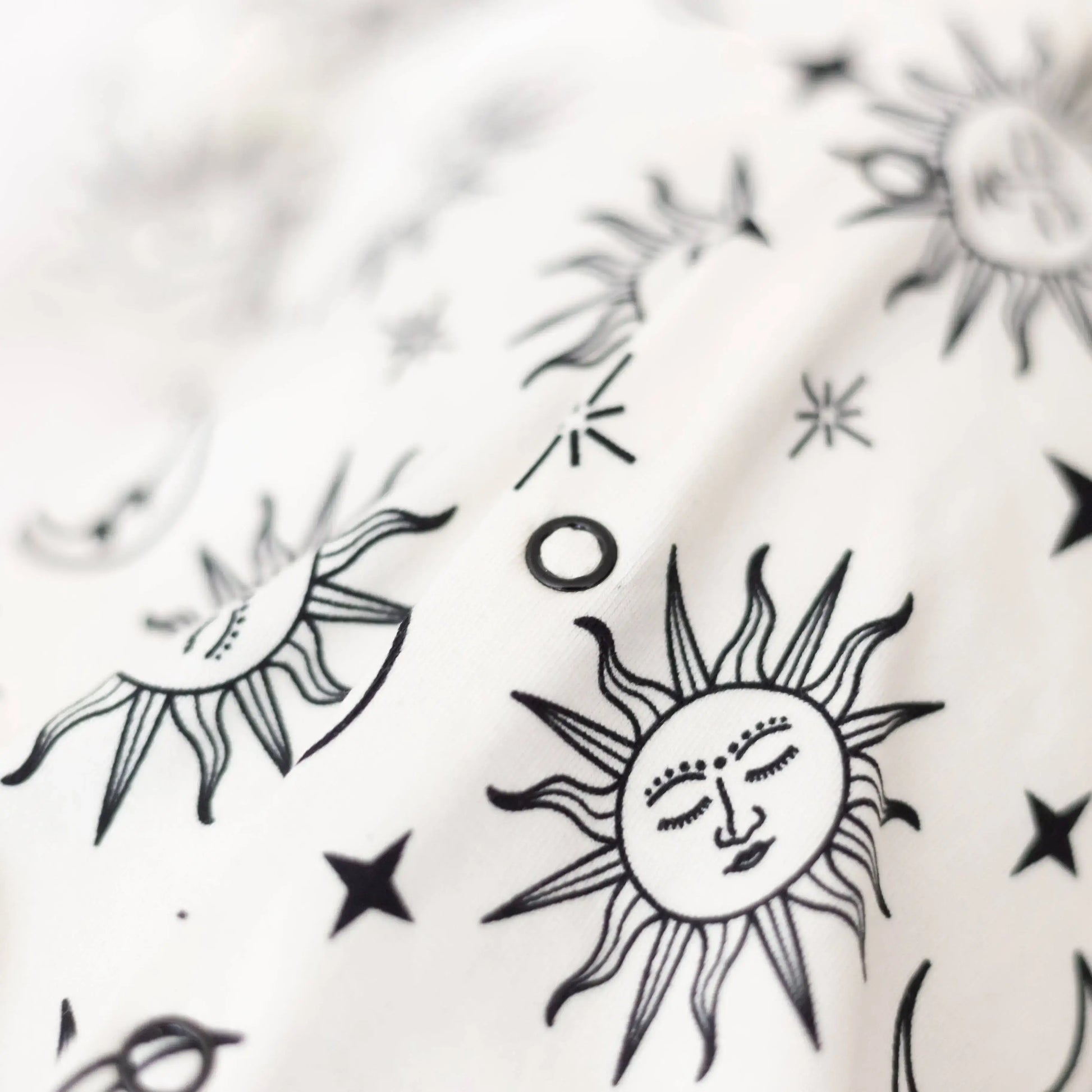 Black and white sun and star designs on a textured white background