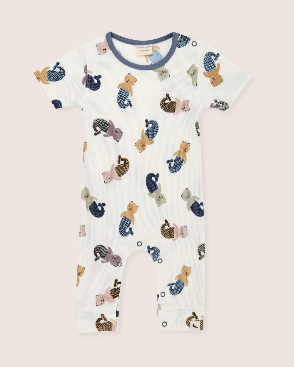 Baby sleepsuit with mermaid and sea-themed print on a light pink background