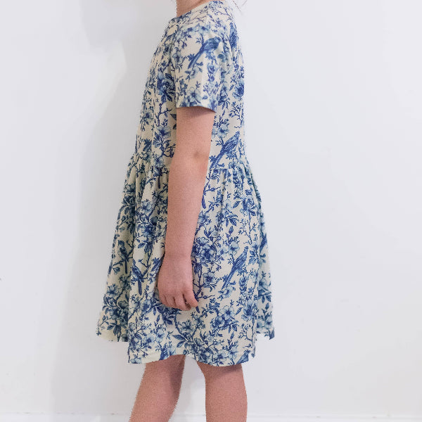 Woman wearing a floral dress with blue patterns on a white background