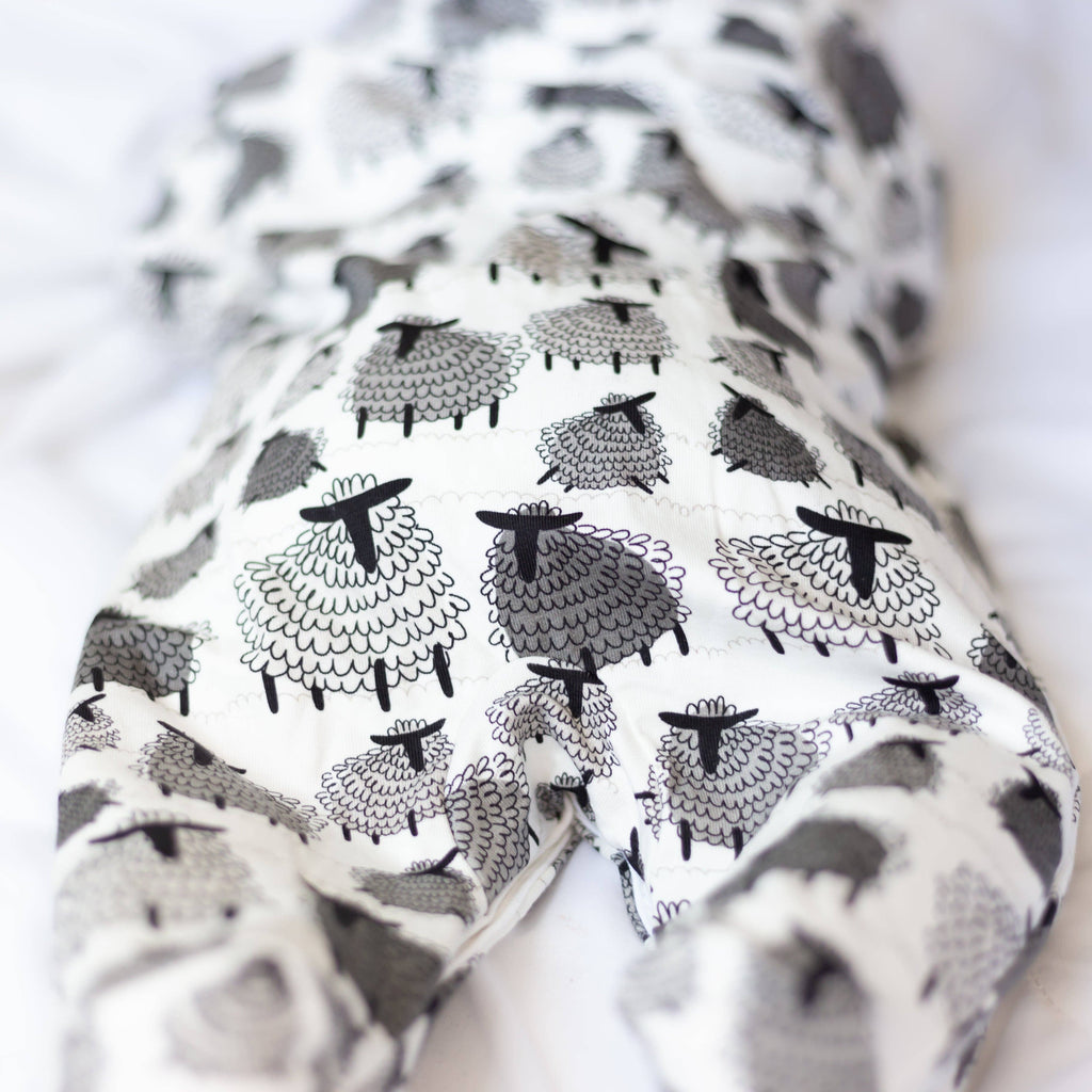 Baby's sleepsuit bottom with black and white sheep pattern on a light background