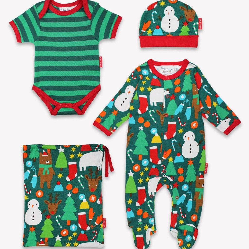 Set of Christmas-themed baby clothing including onesie, hat, and bag on a white background