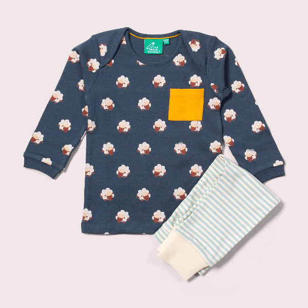 Children's navy long-sleeve shirt with cupcake pattern and yellow pocket, paired with striped pants on a light gray background.
