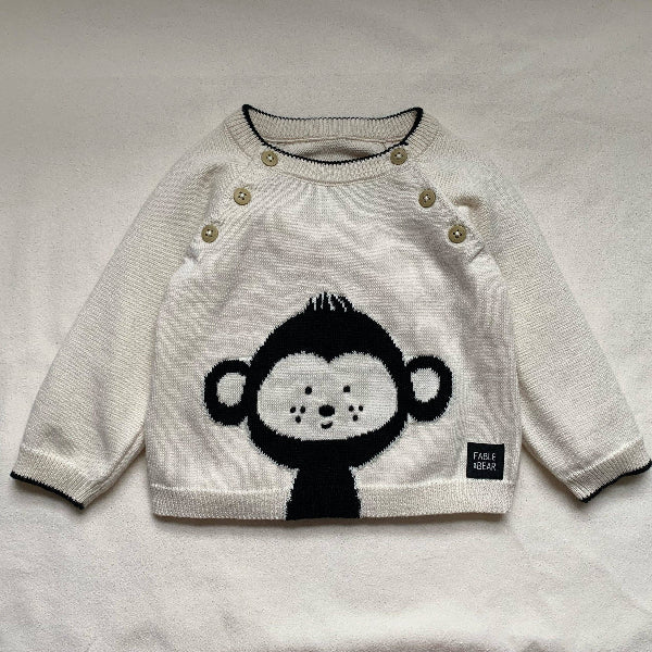 White jumper/sweater with monkey design on a light gray background