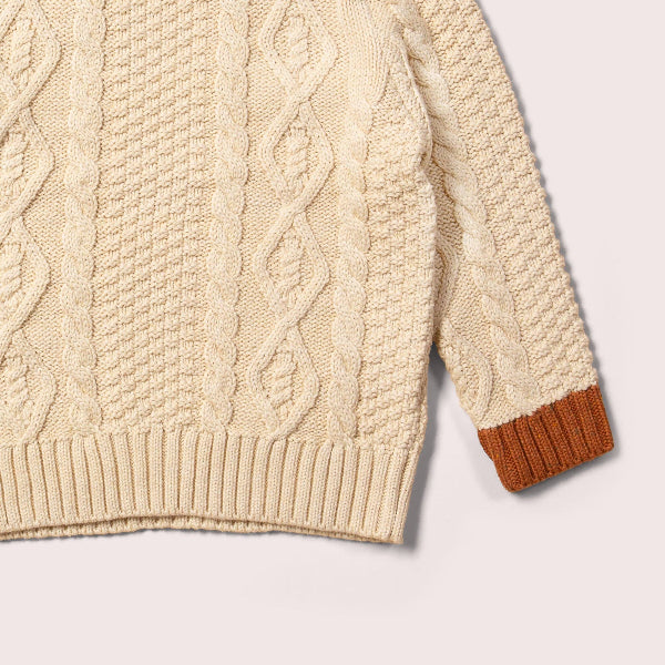 Beige cable knit sweater with brown cuffs on a light gray background