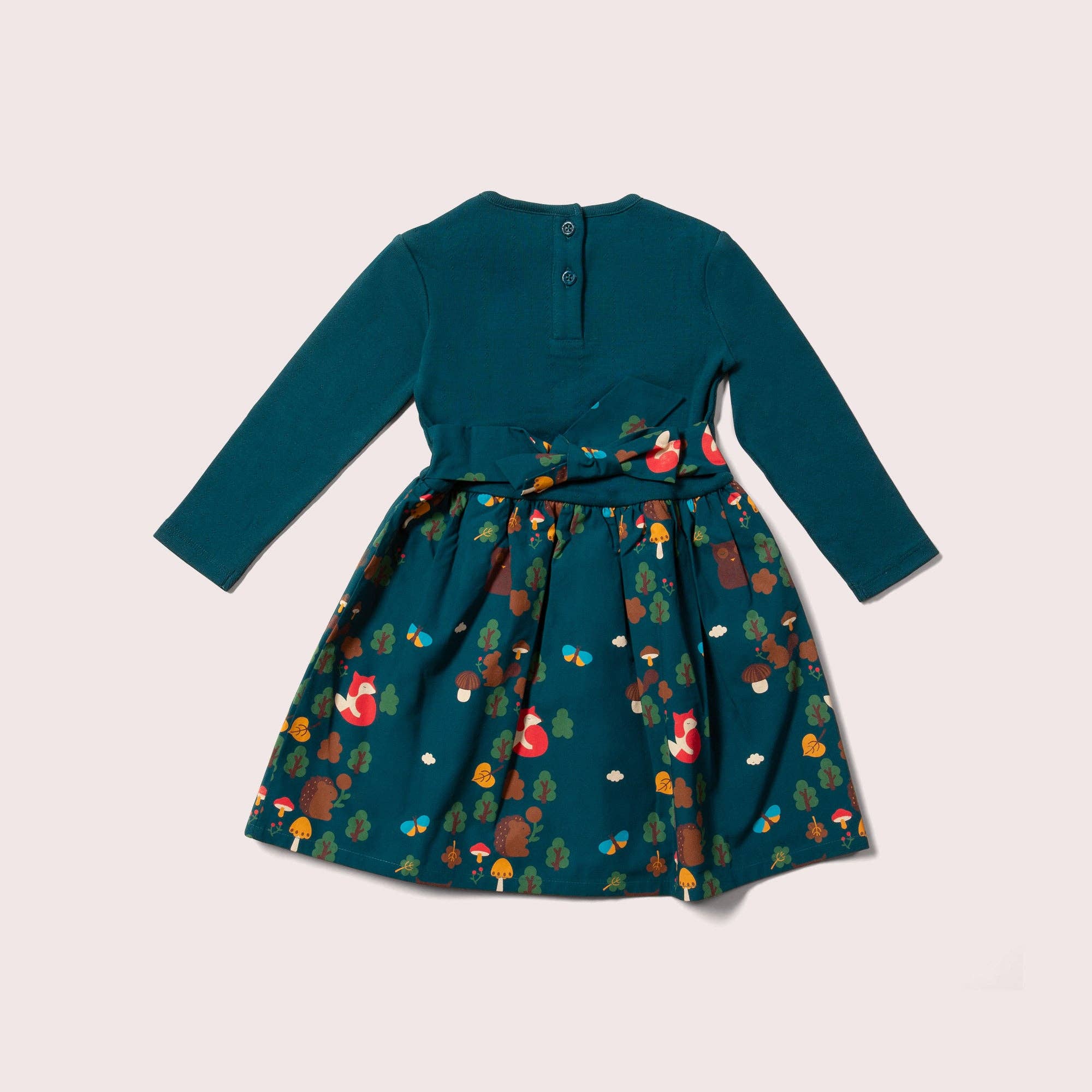 Teal dress with a colorful forest pattern on a light beige background