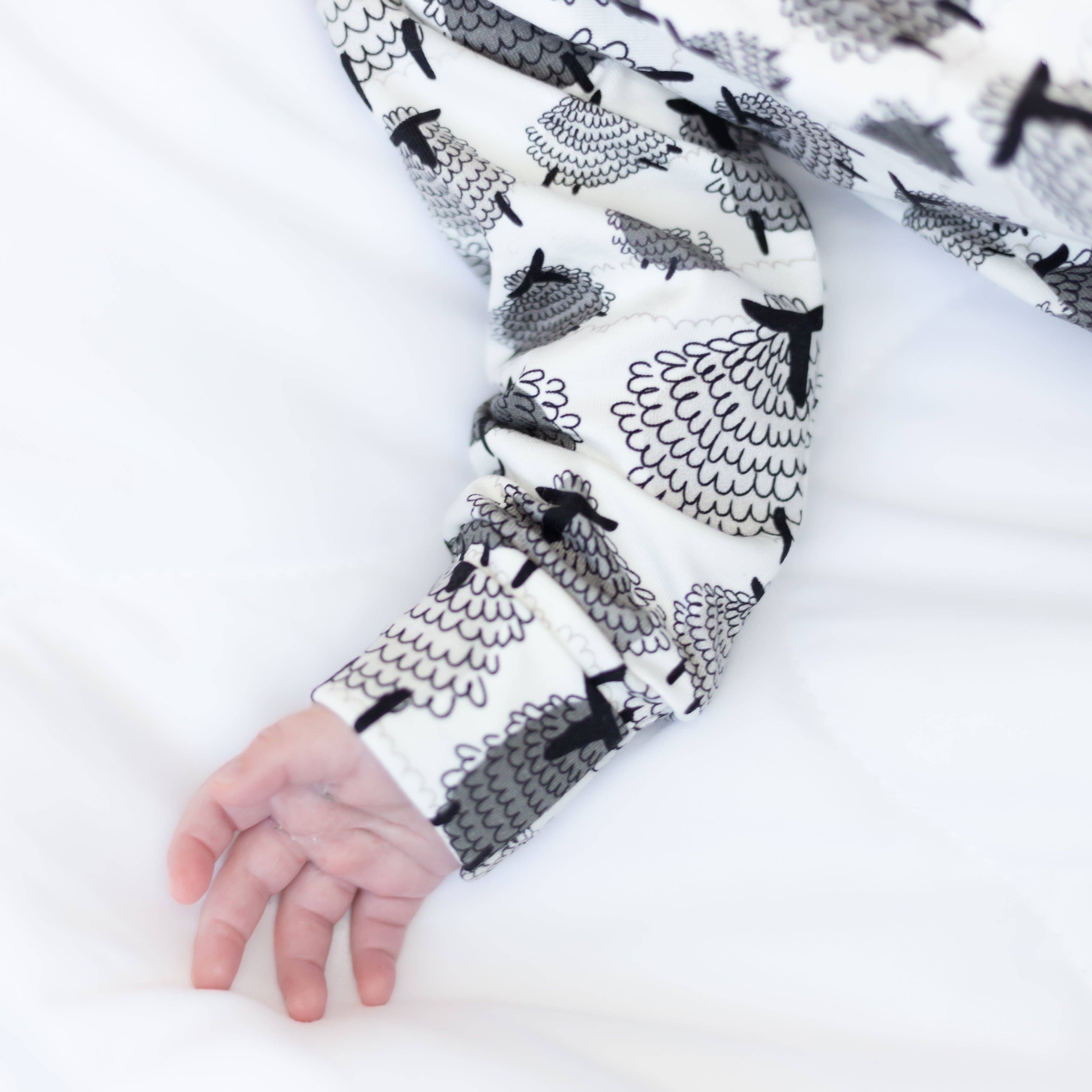Sleepsuit sleeve with black and white pattern of sheep on a white background