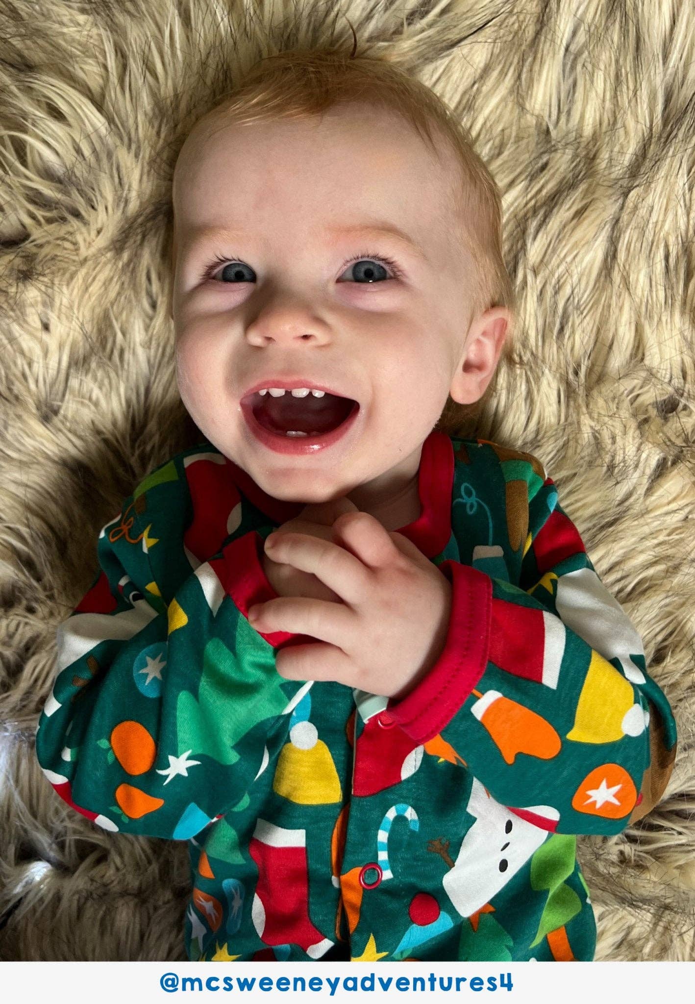 Child wearing a colorful outfit with a pattern of stars, snowmen, and candy canes on a fluffy beige rug.