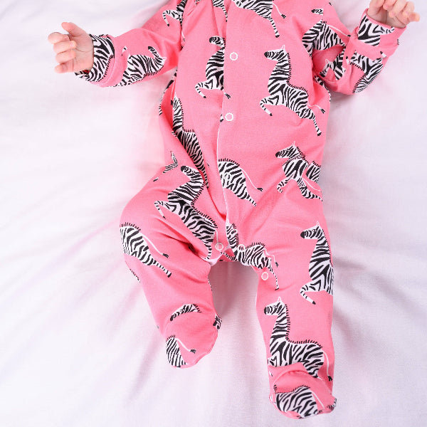 Baby in a pink onesie with zebra pattern on a white background