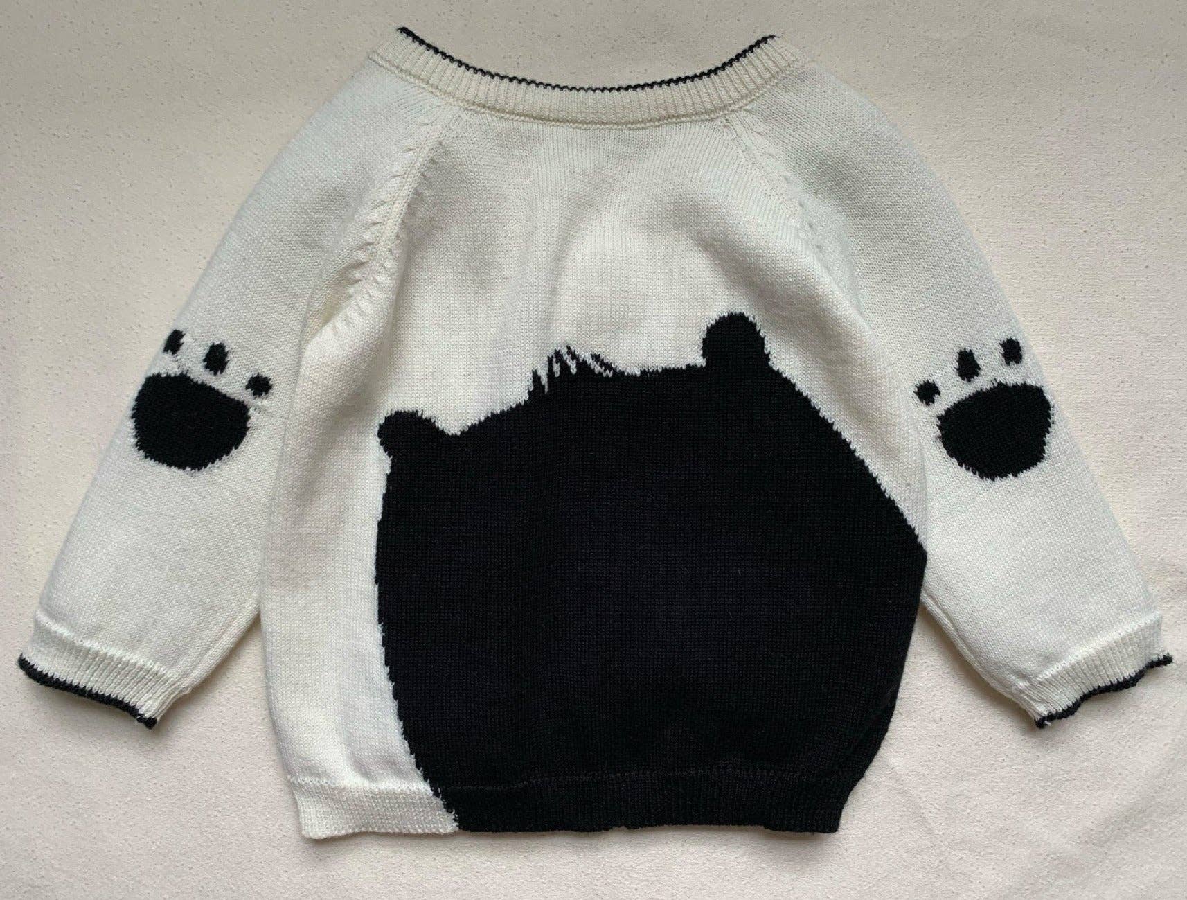 White jumper/sweater with black bear design on a light gray background