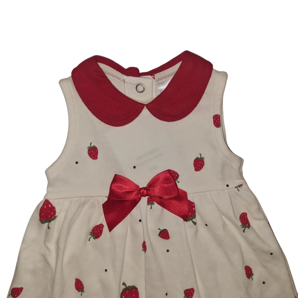 Close-up of white cotton baby dress with red collar, bow, and strawberry print on a white background