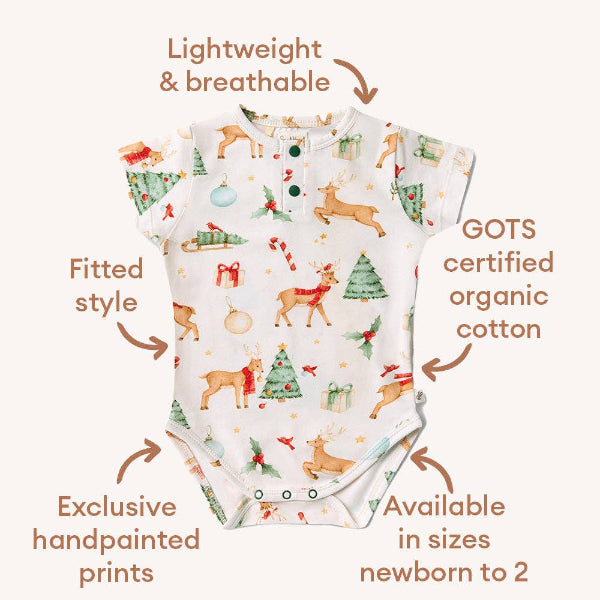 Baby onesie with Christmas-themed design and certification details on a white background