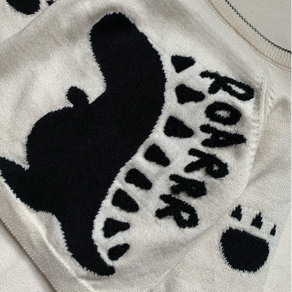 White towel with black dinosaur silhouette and 'ROAR' text on a white background