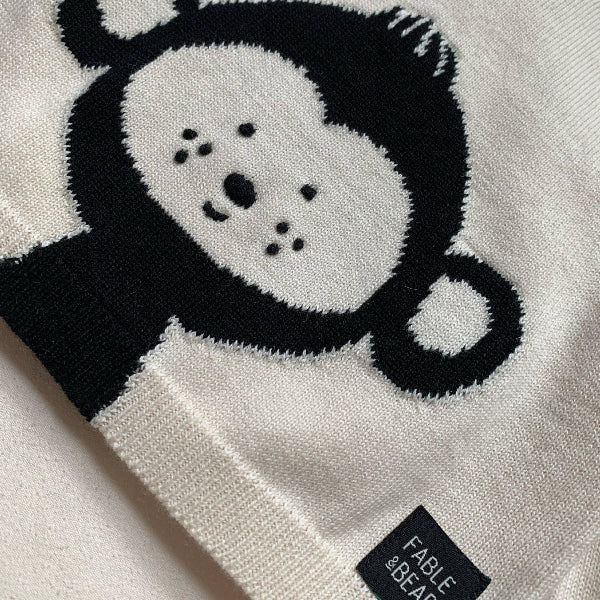 White jumper/sweater with black monkey design and 'Fable & Co.' label on a light gray background