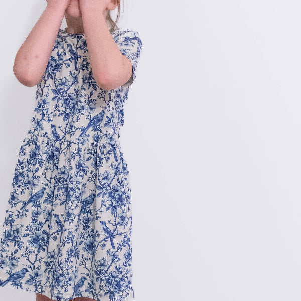 Person wearing a blue floral dress on a white background