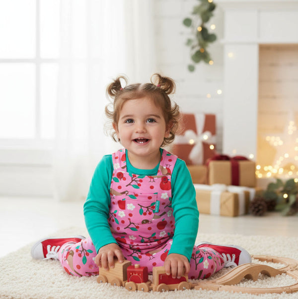 Child in a festive setting with Christmas decorations and presents.