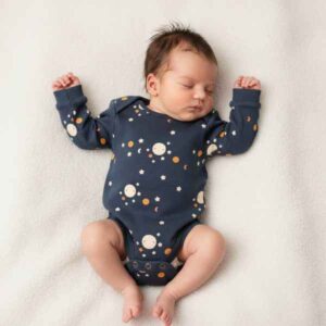 baby wearing dark blue bodysuit with moon print